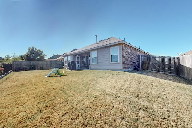 back of house with a lawn