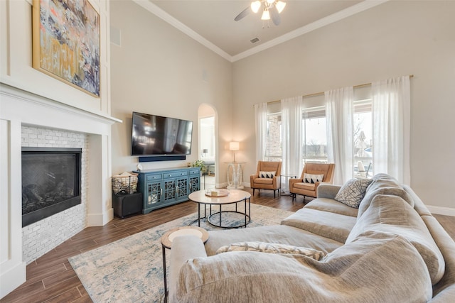 living room featuring a tile fireplace, high vaulted ceiling, ceiling fan, and ornamental molding