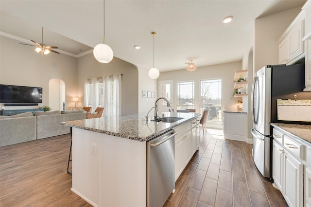 kitchen featuring pendant lighting, a center island with sink, sink, white cabinetry, and stainless steel appliances