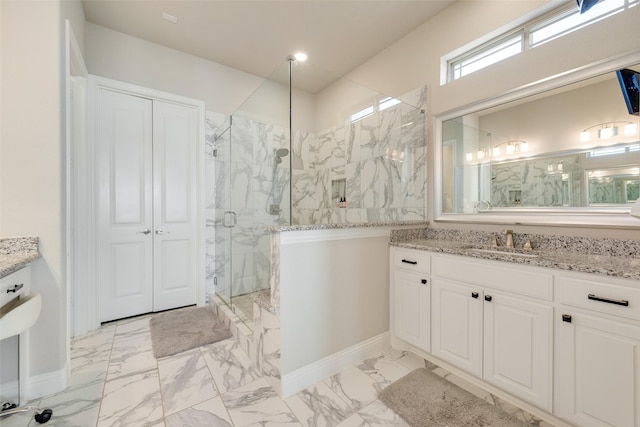 bathroom featuring a shower with door and vanity