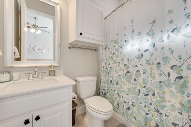 bathroom featuring walk in shower, vanity, toilet, and ceiling fan