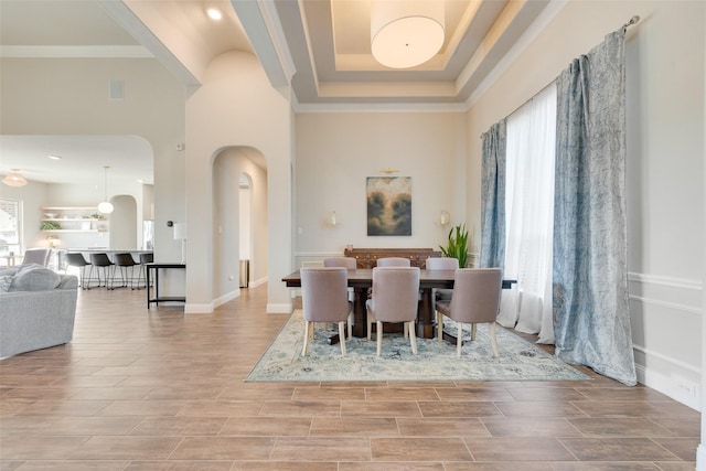 dining area featuring crown molding, a high ceiling, and a tray ceiling