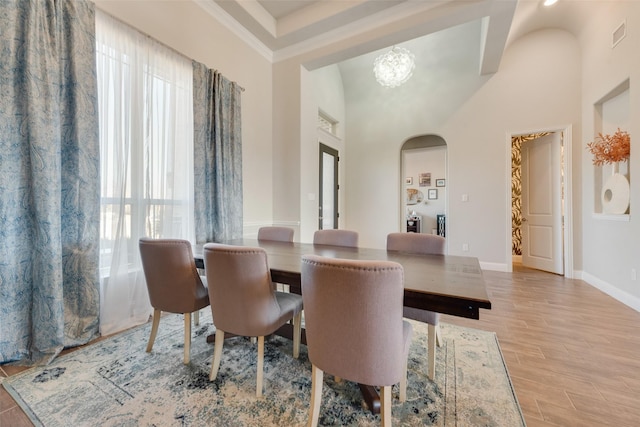 dining room featuring a high ceiling, light hardwood / wood-style floors, and a notable chandelier