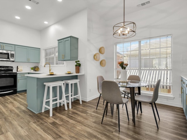 dining area with dark hardwood / wood-style floors, plenty of natural light, and an inviting chandelier