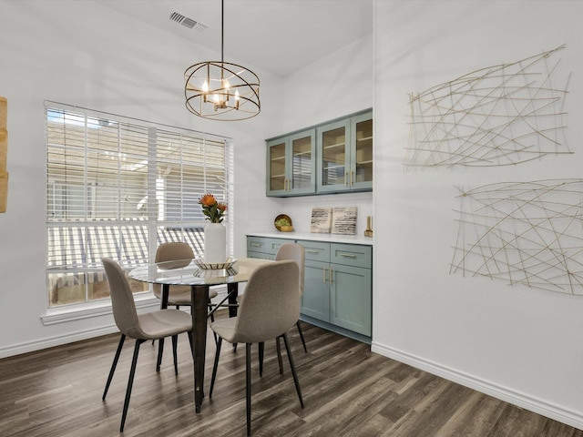 dining room featuring dark wood-type flooring and an inviting chandelier