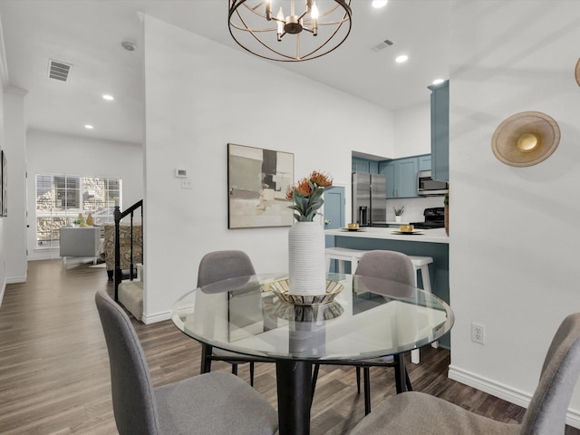 dining area featuring wood-type flooring and a chandelier