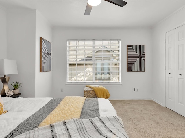 carpeted bedroom featuring a closet, ceiling fan, and ornamental molding