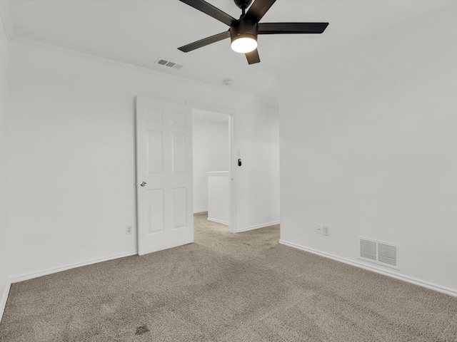 empty room featuring carpet flooring, ceiling fan, and crown molding