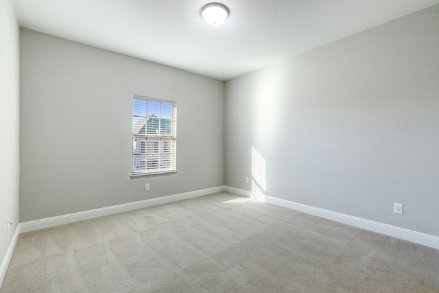 unfurnished room featuring light carpet