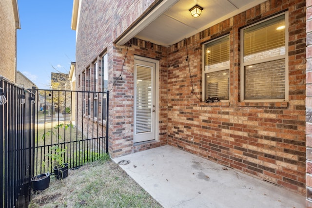 view of exterior entry with a patio area