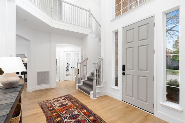 entrance foyer featuring wood-type flooring and a high ceiling