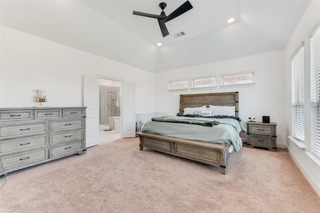 carpeted bedroom with ceiling fan, vaulted ceiling, and ensuite bath