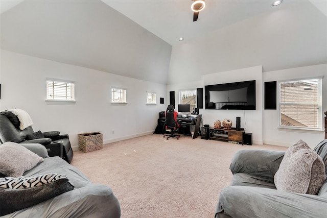 carpeted living room with ceiling fan and high vaulted ceiling