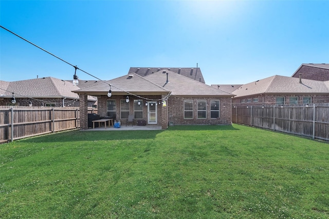 rear view of house with a yard and a patio