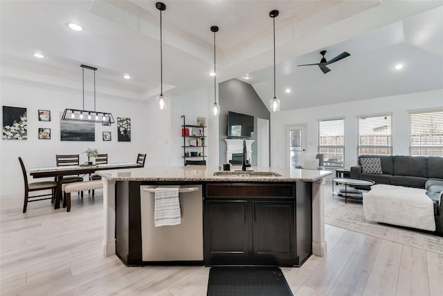 kitchen with ceiling fan, light hardwood / wood-style flooring, hanging light fixtures, and an island with sink