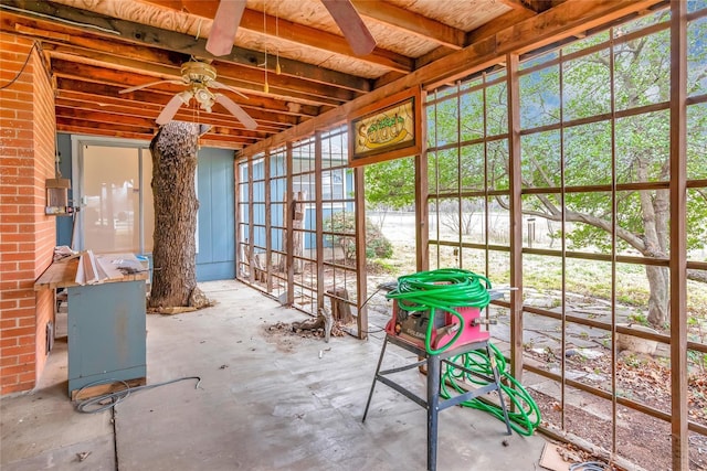 unfurnished sunroom with ceiling fan