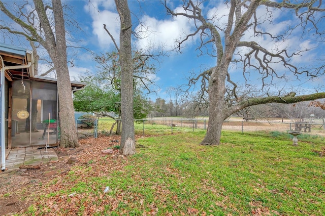 view of yard featuring a sunroom and a rural view