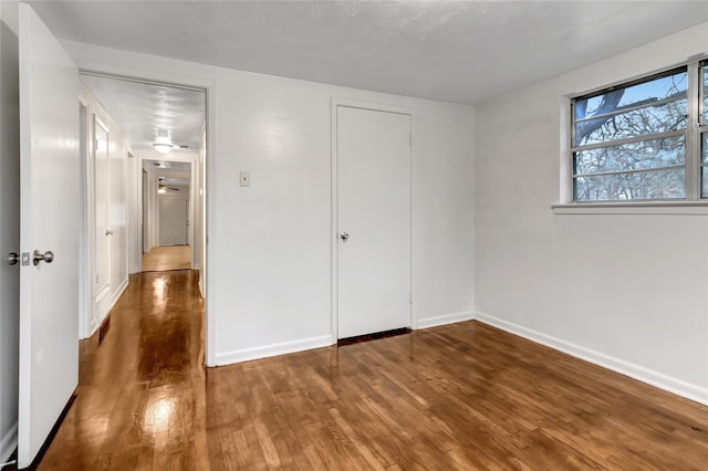 unfurnished bedroom with dark hardwood / wood-style flooring and a closet