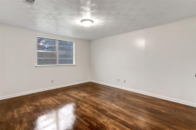 unfurnished room with dark hardwood / wood-style flooring and a textured ceiling