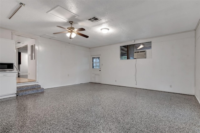 unfurnished living room with ceiling fan, cooling unit, and a textured ceiling