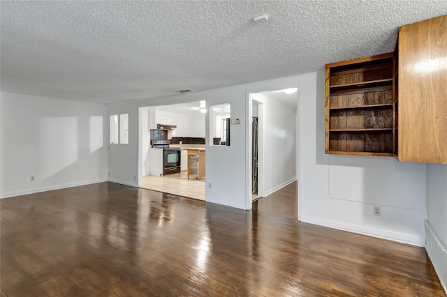 unfurnished living room with a textured ceiling and dark hardwood / wood-style flooring