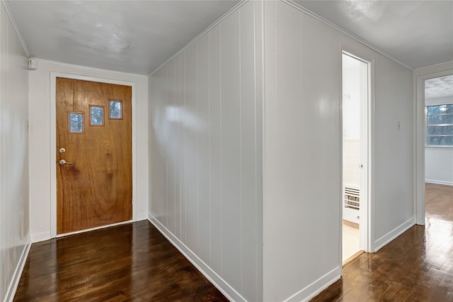 foyer entrance with crown molding and dark hardwood / wood-style floors