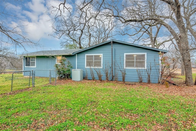 view of home's exterior with cooling unit and a lawn