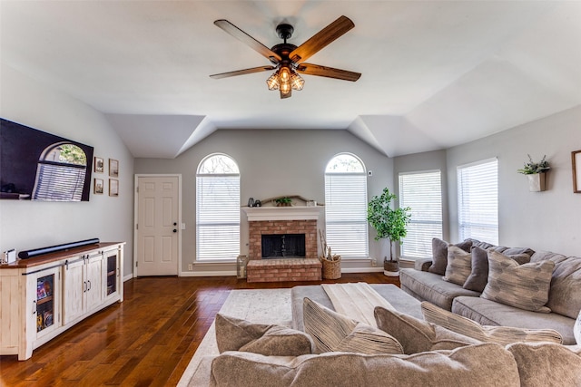 living room featuring a fireplace, dark hardwood / wood-style floors, vaulted ceiling, and ceiling fan