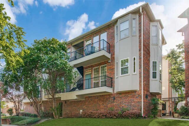 view of front of house featuring a front yard and a balcony