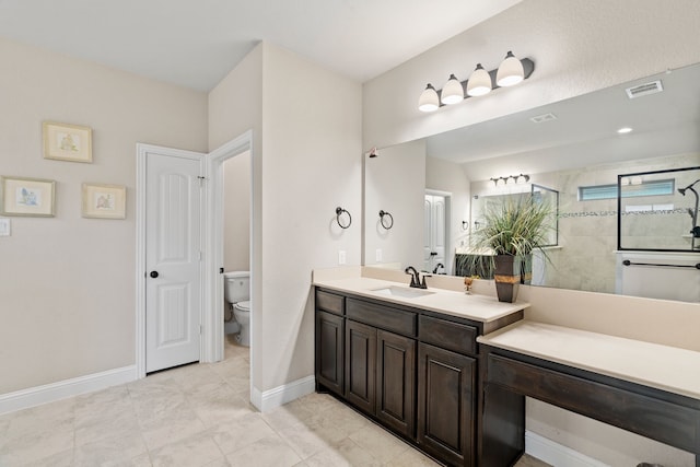 bathroom featuring vanity, a tile shower, and toilet