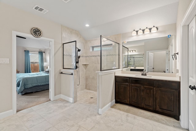 bathroom with a tile shower, vanity, and lofted ceiling