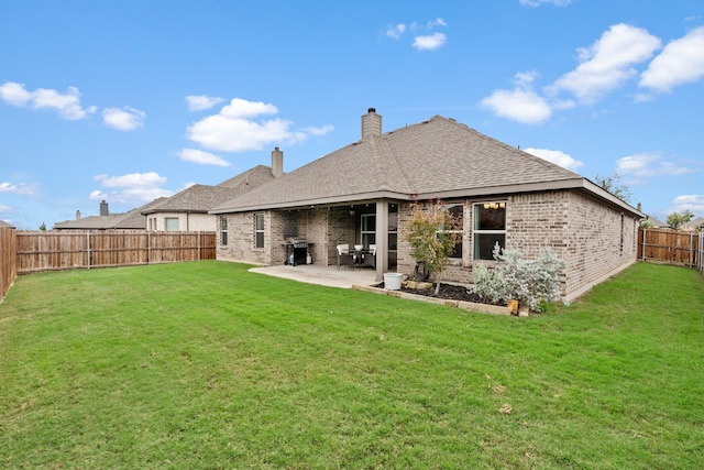 rear view of house with a patio and a lawn