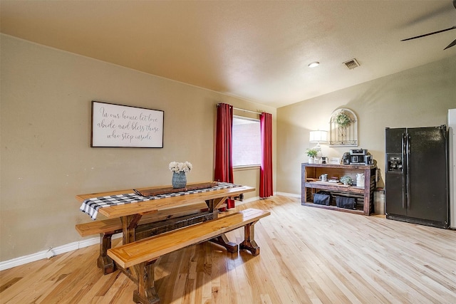 dining room with vaulted ceiling, hardwood / wood-style floors, and ceiling fan