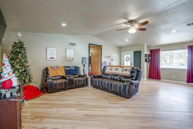 living room with a textured ceiling, ceiling fan, light hardwood / wood-style flooring, and lofted ceiling