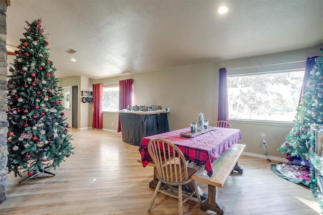 dining room with a textured ceiling and light wood-type flooring