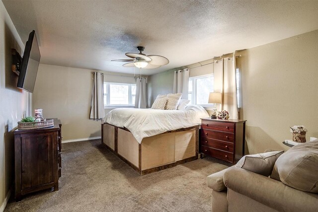 bedroom with dark colored carpet, ceiling fan, and a textured ceiling