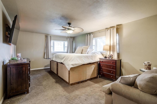 carpeted bedroom featuring a textured ceiling and ceiling fan