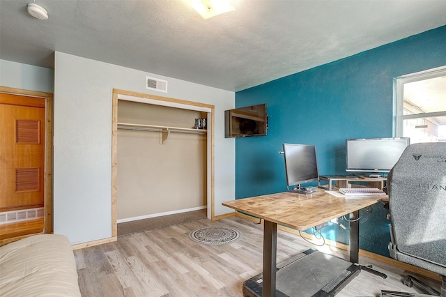 office space featuring a textured ceiling and light hardwood / wood-style floors