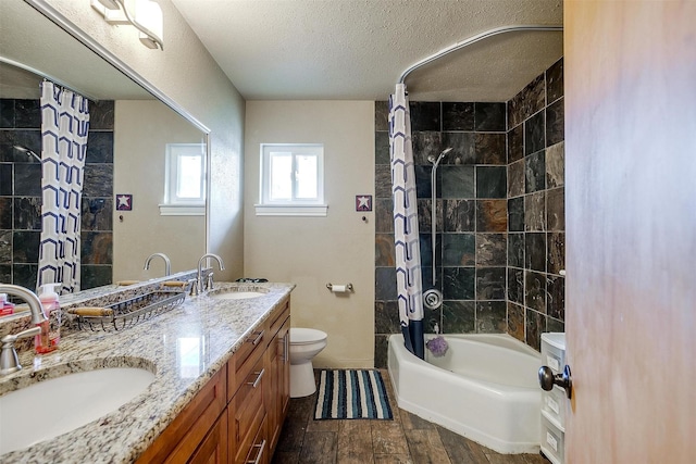 full bathroom featuring vanity, a textured ceiling, shower / bath combo with shower curtain, hardwood / wood-style flooring, and toilet