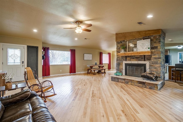 living room with a fireplace, ceiling fan, a textured ceiling, and hardwood / wood-style floors