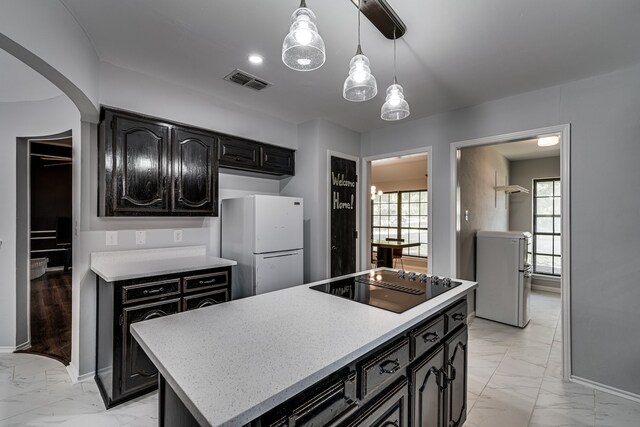 kitchen featuring refrigerator, black electric cooktop, white refrigerator, decorative light fixtures, and a center island