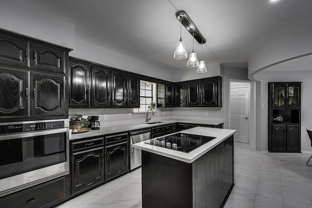 kitchen featuring a center island, stainless steel appliances, decorative light fixtures, and sink