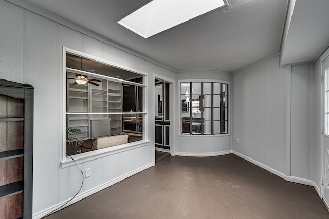 empty room featuring a skylight and ceiling fan