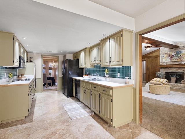 kitchen with black appliances, cream cabinets, and decorative backsplash