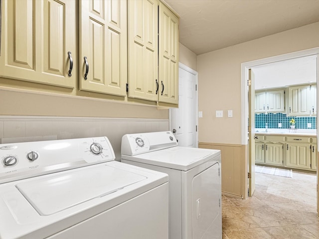 laundry area with independent washer and dryer, cabinets, light tile patterned floors, and sink