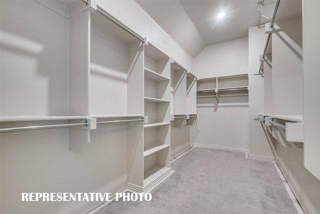 walk in closet featuring light carpet and lofted ceiling