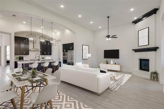 4100 Sandbrock Pkwy, Aubrey, TX 76227 - living area featuring lofted ceiling, light wood-type flooring, a fireplace, recessed lighting, and a ceiling fan