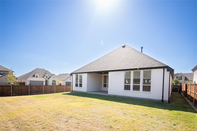 rear view of property with a lawn and a patio