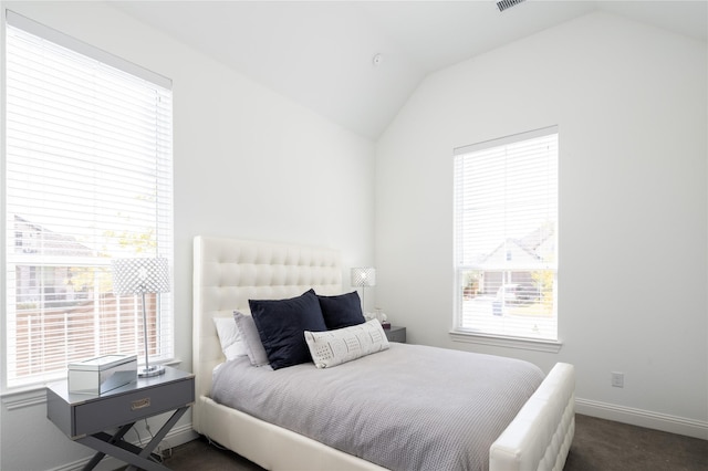 bedroom with vaulted ceiling and multiple windows