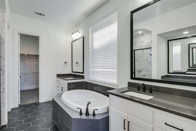 4100 Sandbrock Pkwy, Aubrey, TX 76227 - bathroom featuring a shower stall, a garden tub, a spacious closet, two vanities, and tile patterned flooring